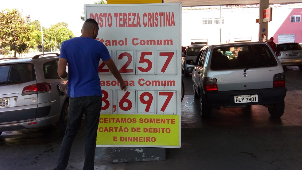 Funcionário muda preço de gasolina em placa de posto de combustível em Belo Horizonte (Foto: Alex Araújo/G1)